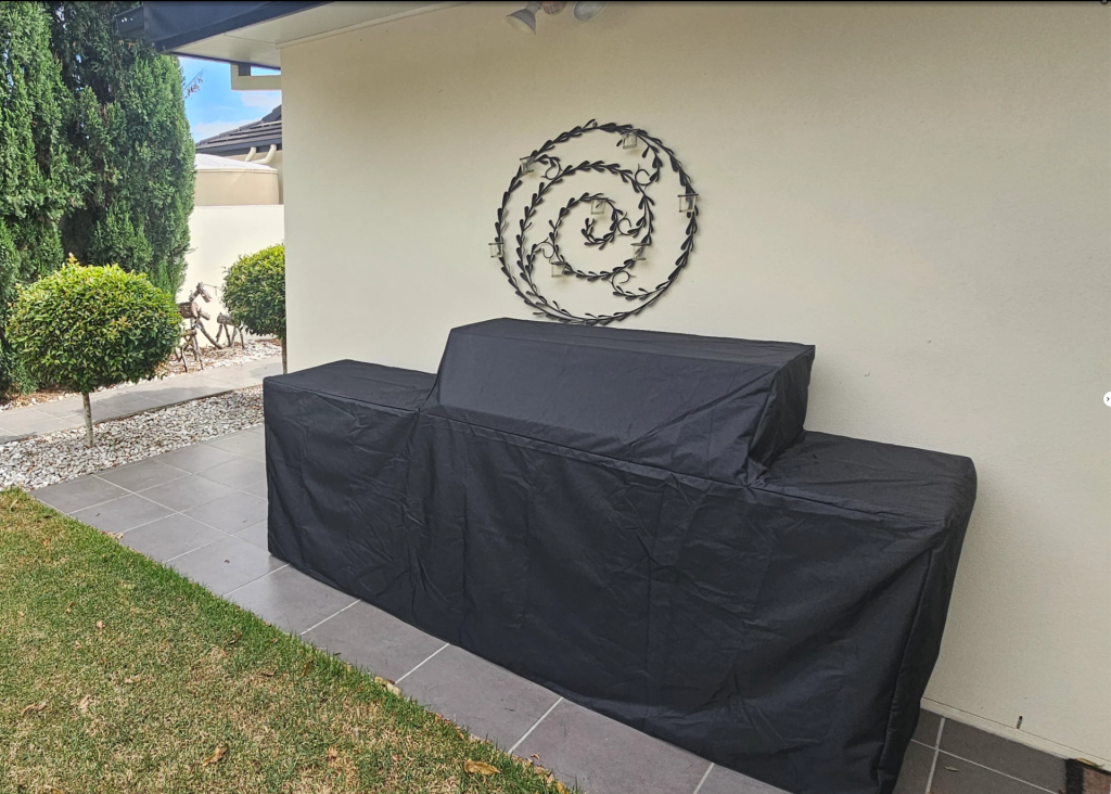 custom-bbq-cover-australia.jpg Custom made BBQ cover in black fitted over a barbecue kitchen – The Cover Company Australia